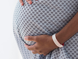 Week 37 pregnant woman in a hospital gown